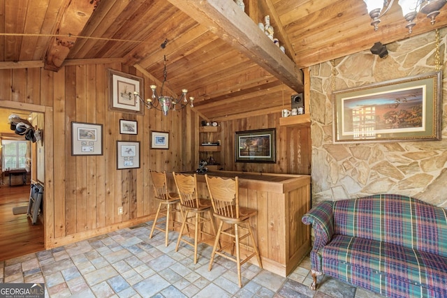 bar with wood walls, lofted ceiling with beams, a notable chandelier, and wooden ceiling