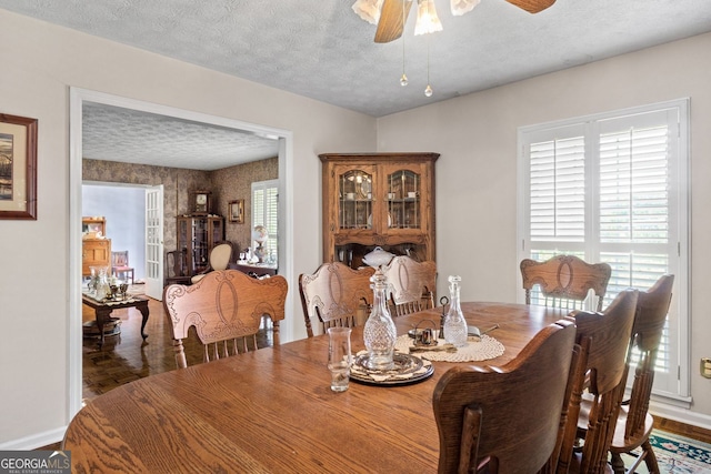 dining room with a textured ceiling, hardwood / wood-style flooring, and ceiling fan