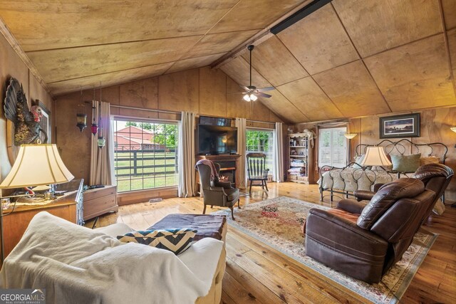 living room with hardwood / wood-style floors, ceiling fan, wooden walls, and wood ceiling