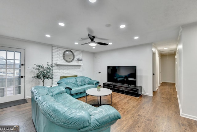 living room featuring wood-type flooring, ceiling fan, and crown molding