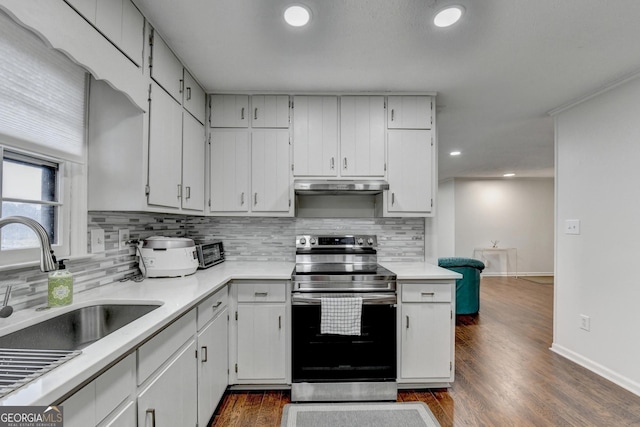 kitchen featuring stainless steel electric stove, sink, white cabinetry, and dark wood-type flooring