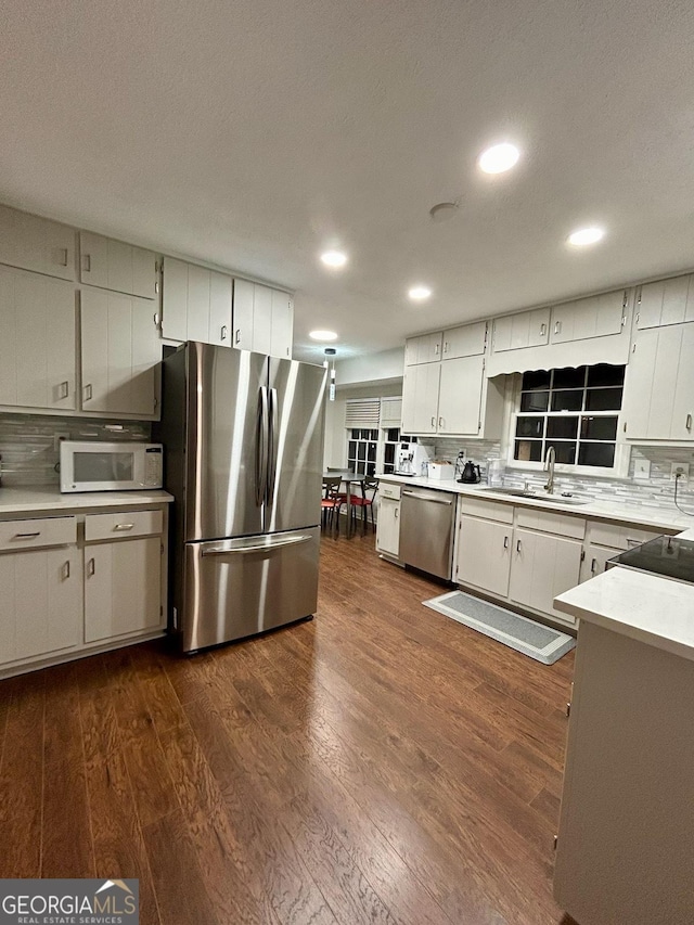 kitchen with white cabinets, dark hardwood / wood-style flooring, stainless steel appliances, and sink