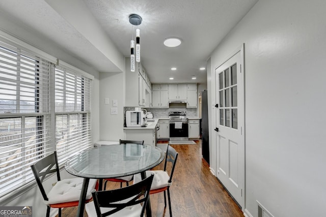 dining room featuring a textured ceiling and dark hardwood / wood-style floors