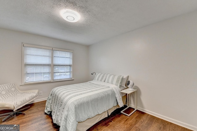 bedroom with dark wood-type flooring and a textured ceiling