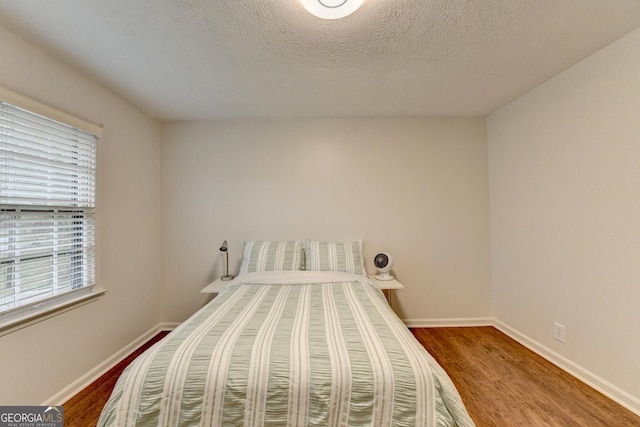 bedroom with wood-type flooring and a textured ceiling