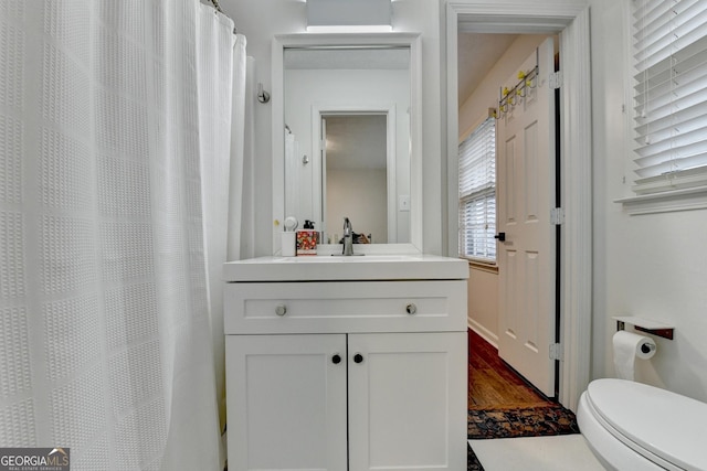 bathroom featuring hardwood / wood-style floors, plenty of natural light, toilet, and vanity