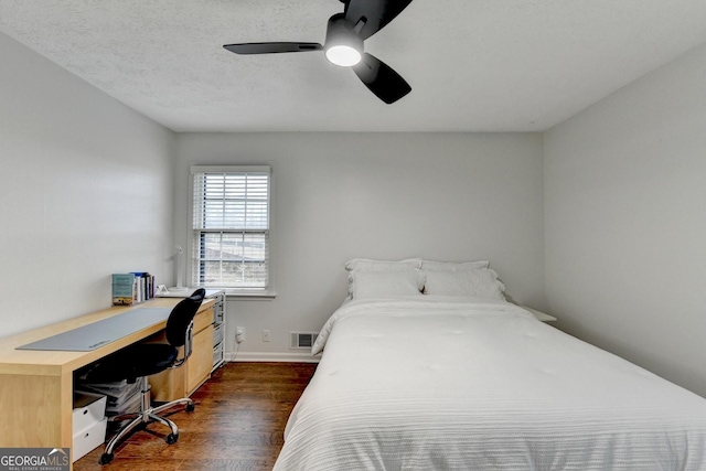 bedroom featuring a textured ceiling, dark hardwood / wood-style floors, and ceiling fan