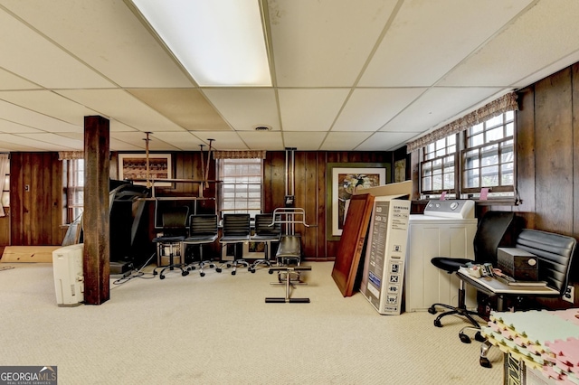 misc room featuring wood walls, a healthy amount of sunlight, washer / dryer, and light colored carpet