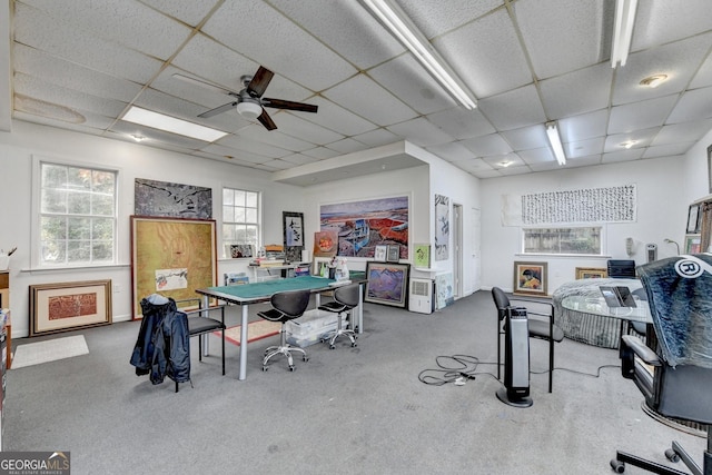 carpeted home office featuring a paneled ceiling, a wealth of natural light, and ceiling fan