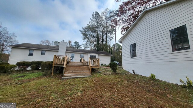 back of property with a yard and a deck