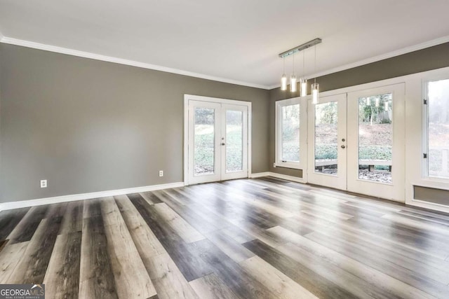 empty room with rail lighting, dark hardwood / wood-style flooring, crown molding, and french doors