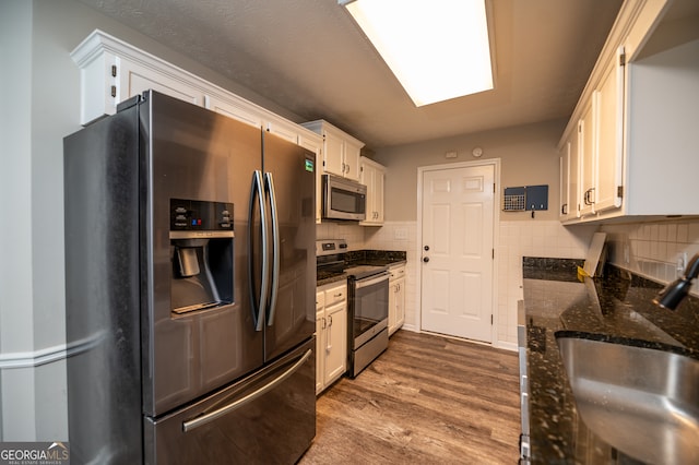 kitchen featuring white cabinets, hardwood / wood-style floors, and stainless steel appliances