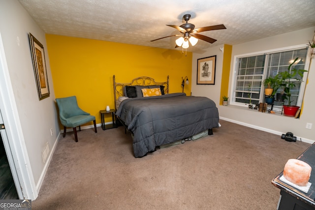 bedroom with a textured ceiling, carpet floors, and ceiling fan