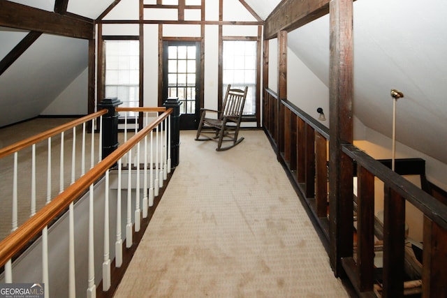 hall featuring light colored carpet and vaulted ceiling