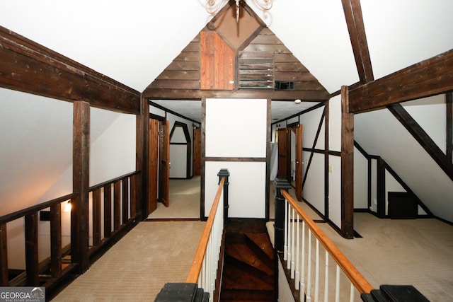 stairway with carpet flooring and vaulted ceiling