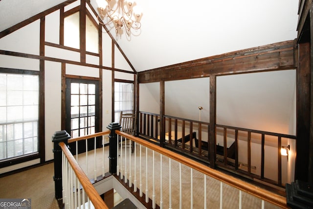 stairs with carpet, high vaulted ceiling, and a chandelier