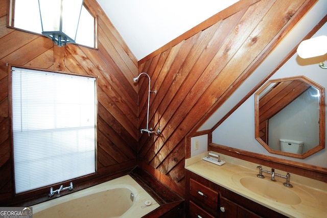 bathroom with vanity, wood walls, toilet, and vaulted ceiling