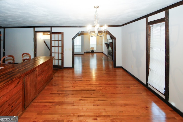 unfurnished dining area with hardwood / wood-style floors, a wealth of natural light, and a chandelier