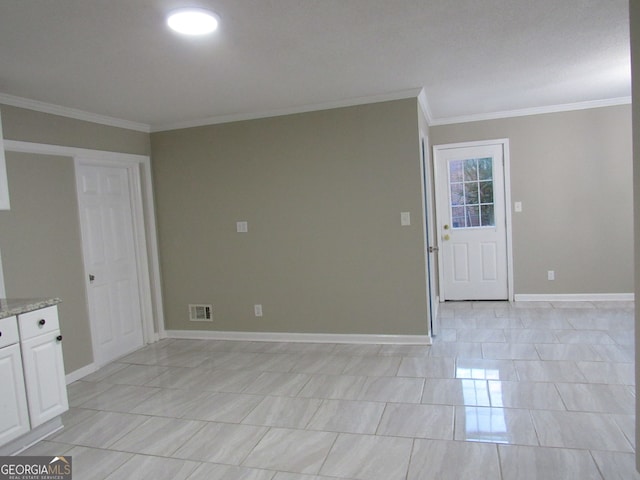 empty room with light tile patterned floors and crown molding