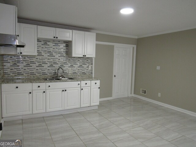 kitchen with tasteful backsplash, sink, and white cabinets