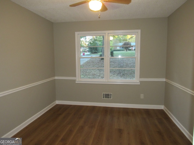 empty room with a textured ceiling, dark hardwood / wood-style floors, and ceiling fan