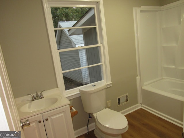 full bathroom featuring bathtub / shower combination, vanity, hardwood / wood-style flooring, and toilet