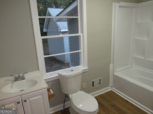 full bathroom with hardwood / wood-style floors, vanity, toilet, and shower / tub combination