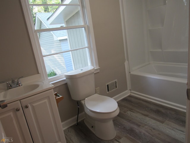 full bathroom with hardwood / wood-style floors, vanity,  shower combination, and toilet