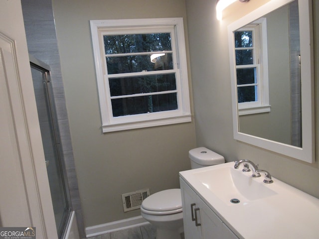 full bathroom featuring combined bath / shower with glass door, vanity, and toilet