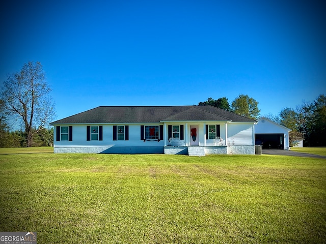 single story home featuring a porch, an outbuilding, a front yard, and a garage