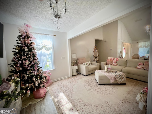 living room with a textured ceiling, a chandelier, vaulted ceiling, and light wood-type flooring