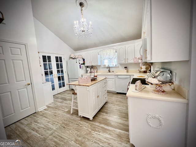 kitchen featuring french doors, white appliances, light hardwood / wood-style flooring, white cabinets, and a kitchen island