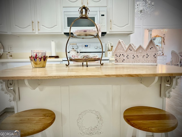 kitchen featuring a kitchen breakfast bar and white cabinetry