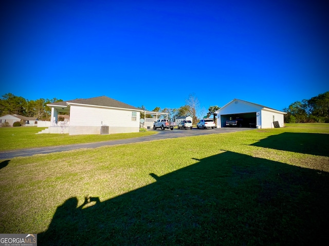 view of yard featuring a garage and an outbuilding