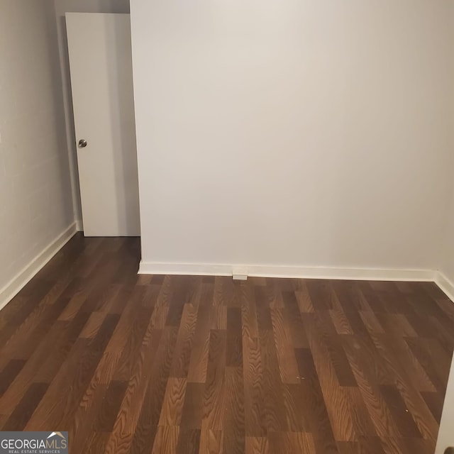 unfurnished room with dark hardwood / wood-style flooring