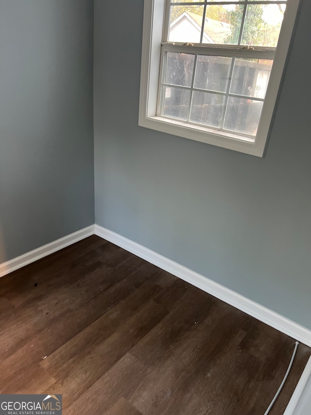 empty room with dark hardwood / wood-style flooring