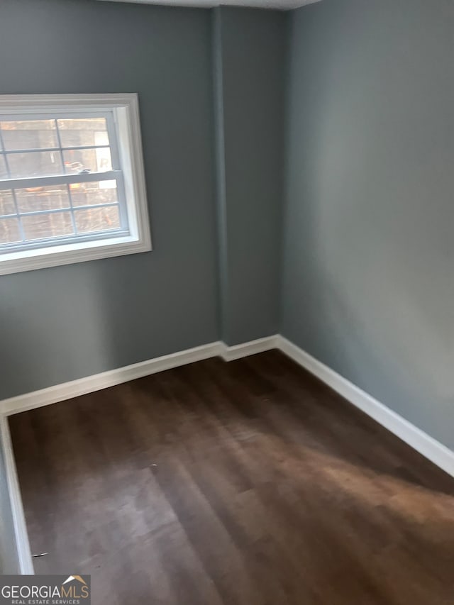 unfurnished room with dark hardwood / wood-style floors