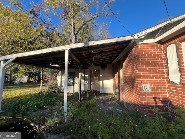 view of parking / parking lot with a carport and a lawn