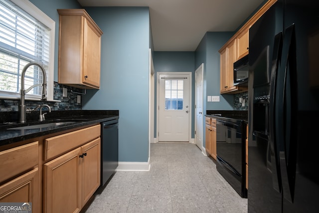 kitchen with decorative backsplash, a wealth of natural light, dark stone countertops, and black appliances