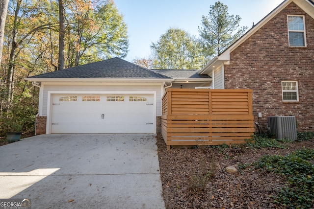 view of side of home with central AC and a garage