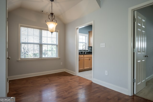 unfurnished dining area featuring dark wood-type flooring, lofted ceiling, and sink