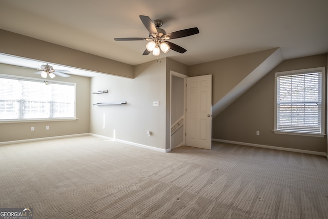 interior space featuring a wealth of natural light, ceiling fan, and light carpet