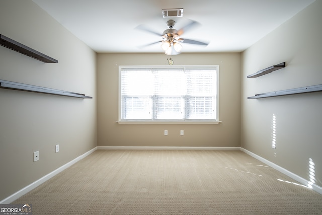 spare room with ceiling fan and light carpet