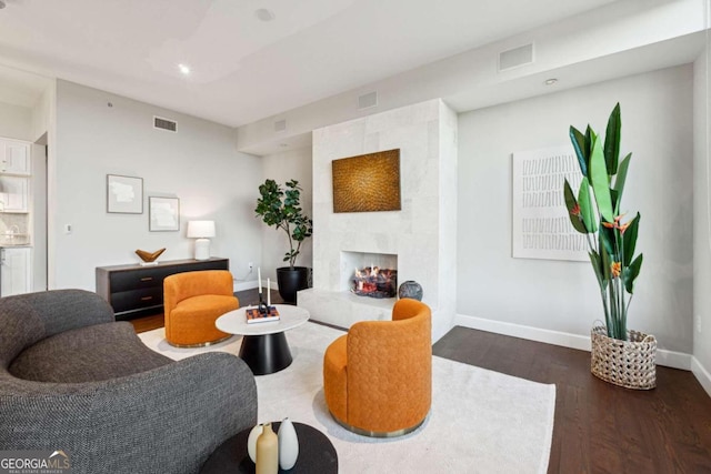 living room featuring a high end fireplace and dark hardwood / wood-style flooring