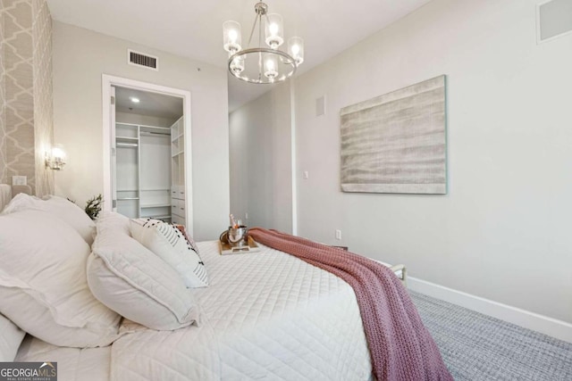 bedroom featuring carpet, a chandelier, a spacious closet, and a closet