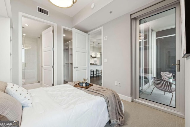 bedroom with ensuite bath, light colored carpet, and access to exterior