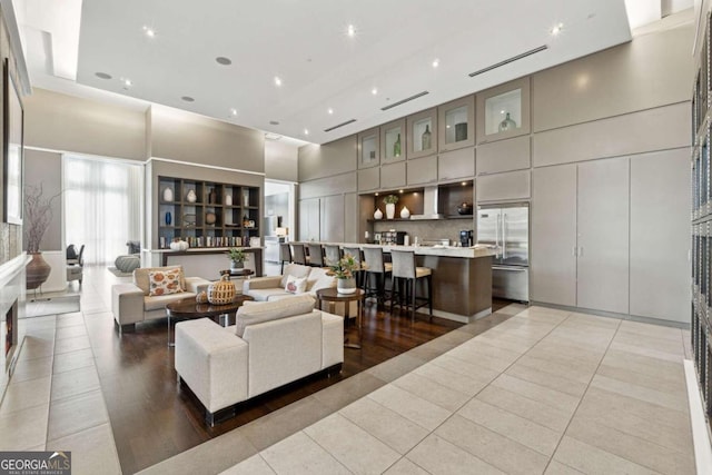 living room with light tile patterned floors and a high ceiling