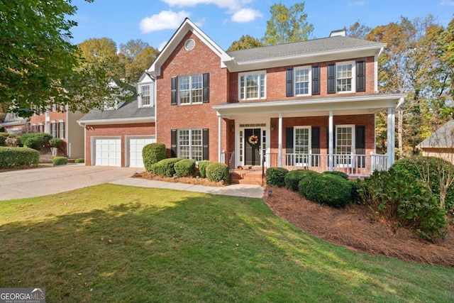 colonial-style house featuring covered porch, a garage, and a front lawn