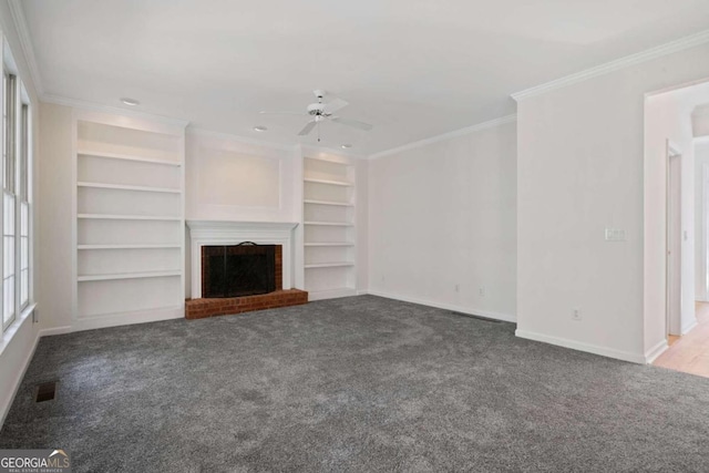 unfurnished living room with a fireplace, built in shelves, ceiling fan, and ornamental molding