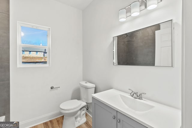 bathroom with hardwood / wood-style flooring, toilet, and vanity